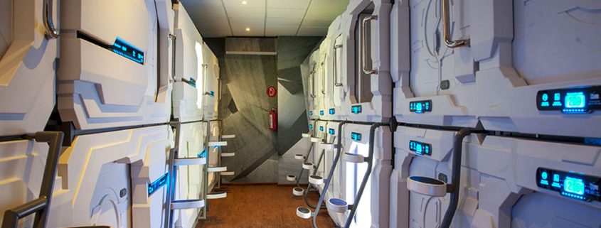 A look into the capsule/pod area at Izzzleep Capsule Hotel, showing the two levels of pods anda the steps to ge to the upper-level pods.