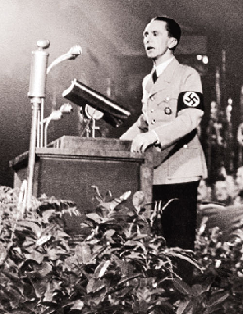 A vintage black-and-white photo of Joseph Goebbels, Hitler's Propaganda Minister, speaking at a Nazi rally.